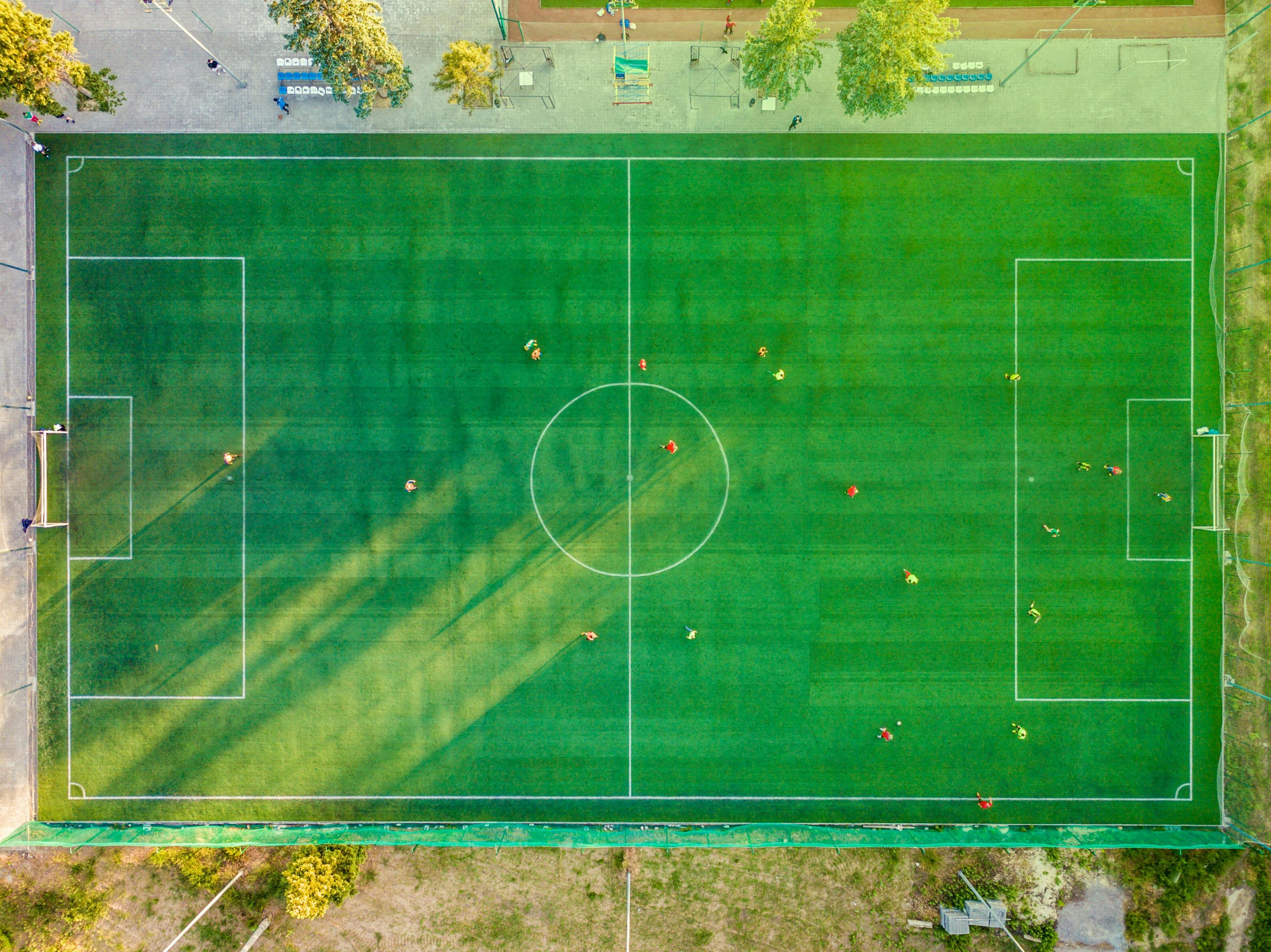 Ein Fußballfeld samt Mannschaft wird aus der Vogelperspektive gezeigt. 